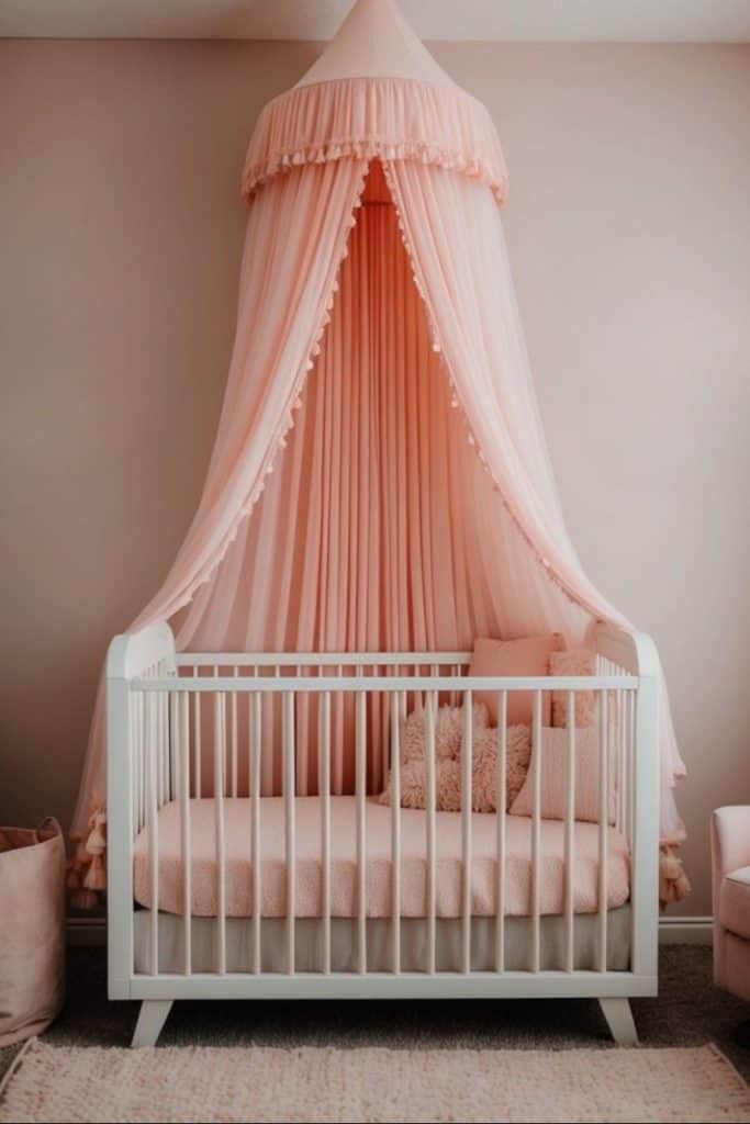 A white crib with pink bedding is adorned with a pink, draped canopy. The nursery features soft, neutral tones and has a plush pillow inside the crib. A pink wall complements the overall soothing ambiance.