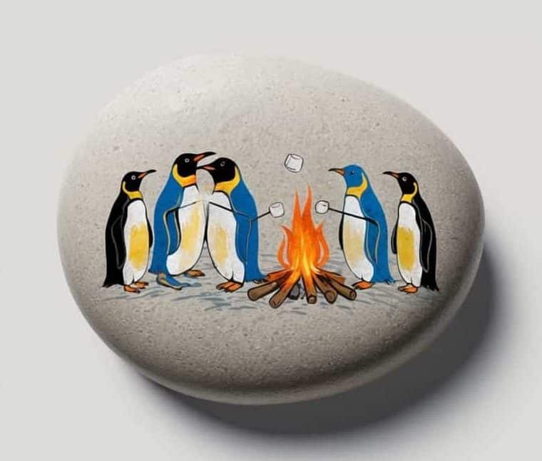 Illustrations of penguins roasting marshmallows around a campfire, shown on paper, painted on a stone, and in a repeated pattern.