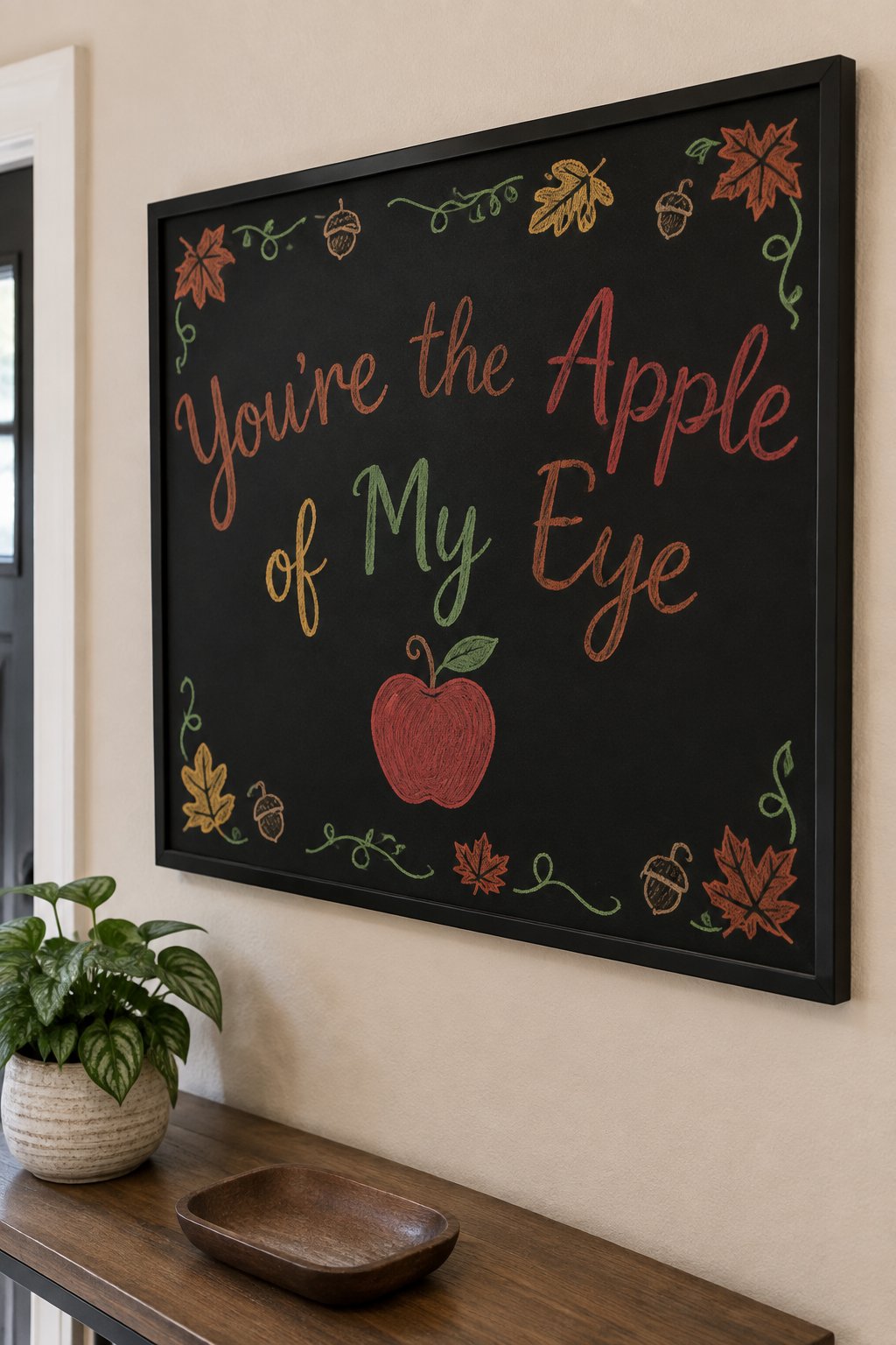 Apple of My Eye Board: a framed fall chalkboard sign reading "You're the Apple of My Eye", hand-drawn in chalk with a single red apple with a curled stem and one leaf.