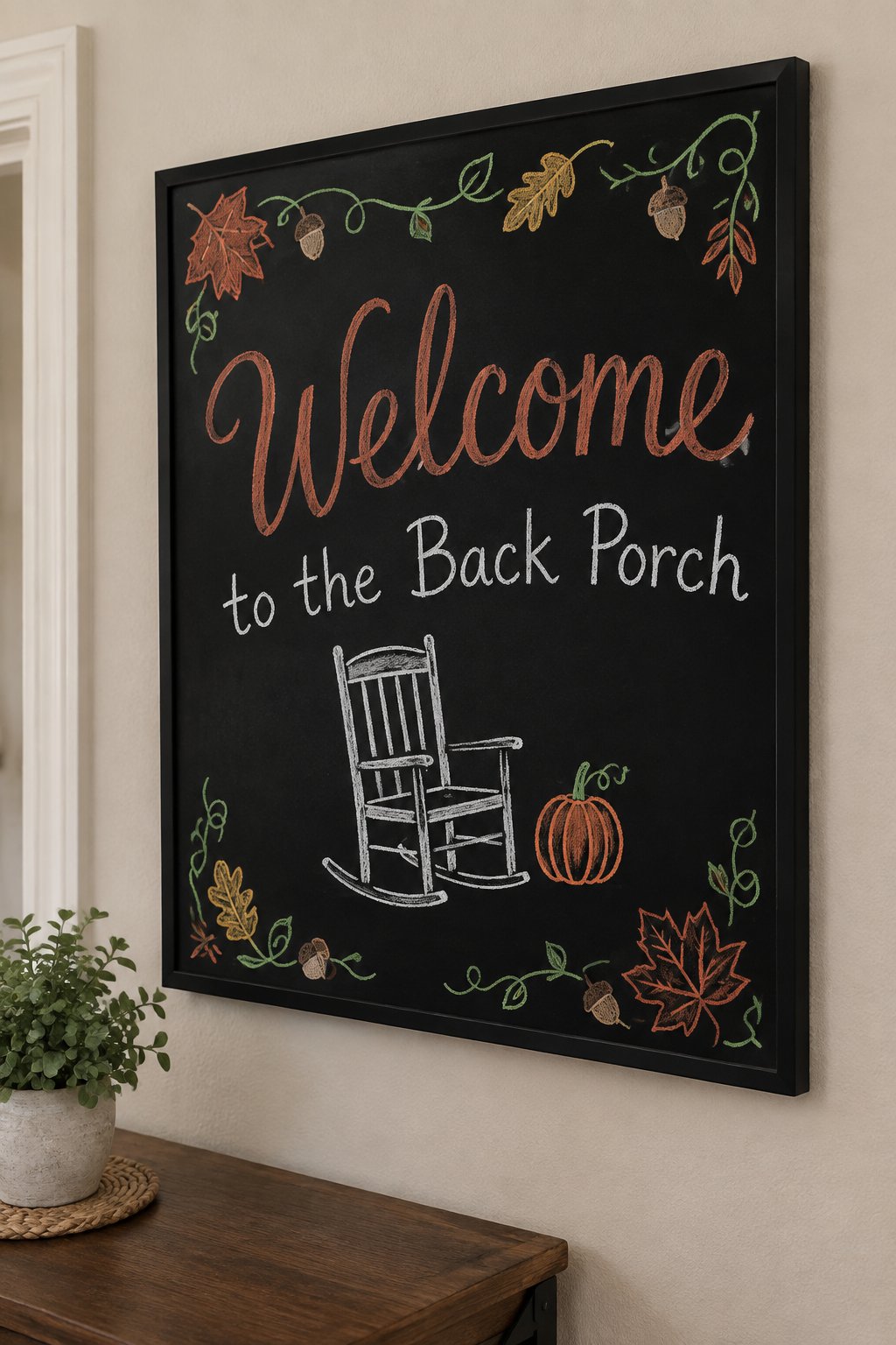 Back Porch Welcome: a framed fall chalkboard sign reading "Welcome to the Back Porch", hand-drawn in chalk with a rocking chair beside a small pumpkin.