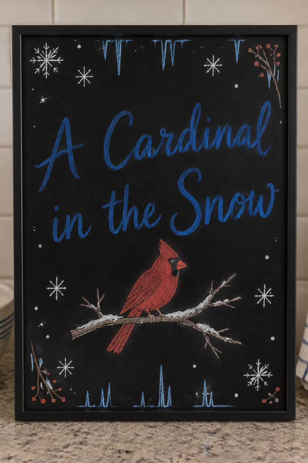 Cardinal in the Snow Board: a framed winter chalkboard sign reading "A Cardinal in the Snow", hand-drawn in chalk with one cardinal perched on a bare branch dusted with snow.