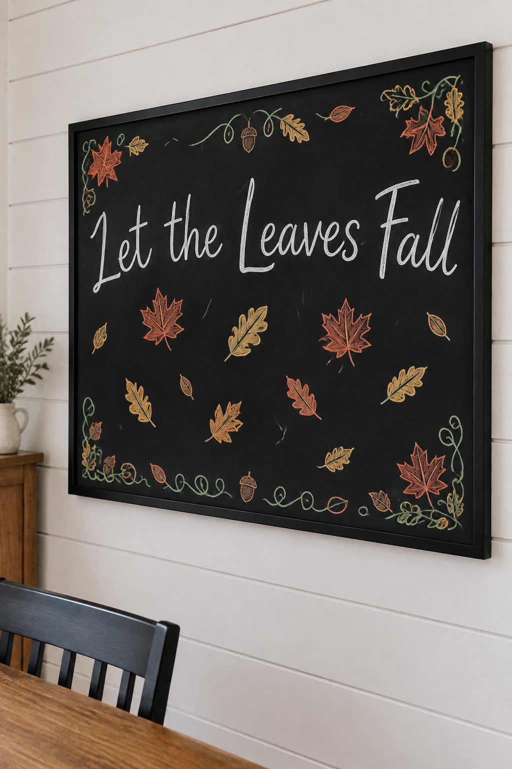 Falling Leaves Board: a framed fall chalkboard sign reading "Let the Leaves Fall", hand-drawn in chalk with a scatter of maple and oak leaves drifting down.