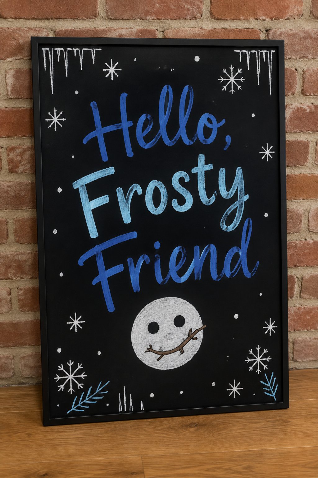 Frosty Friend Board: a framed winter chalkboard sign reading "Hello, Frosty Friend", hand-drawn in chalk with one round snowman face with coal eyes and a crooked twig smile.